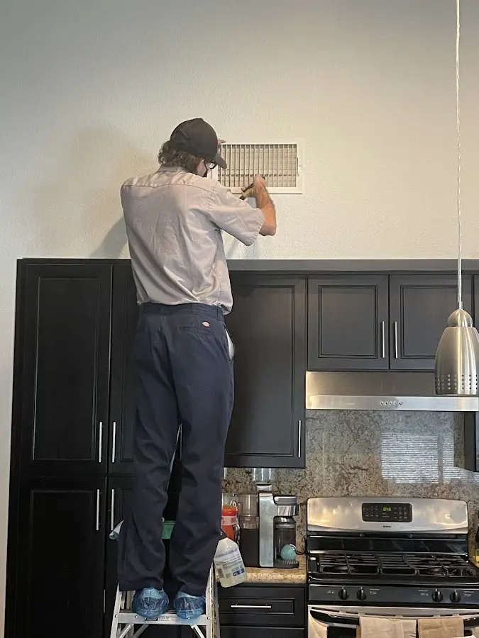 Technician inspecting an air vent during HVAC service in Pflugerville